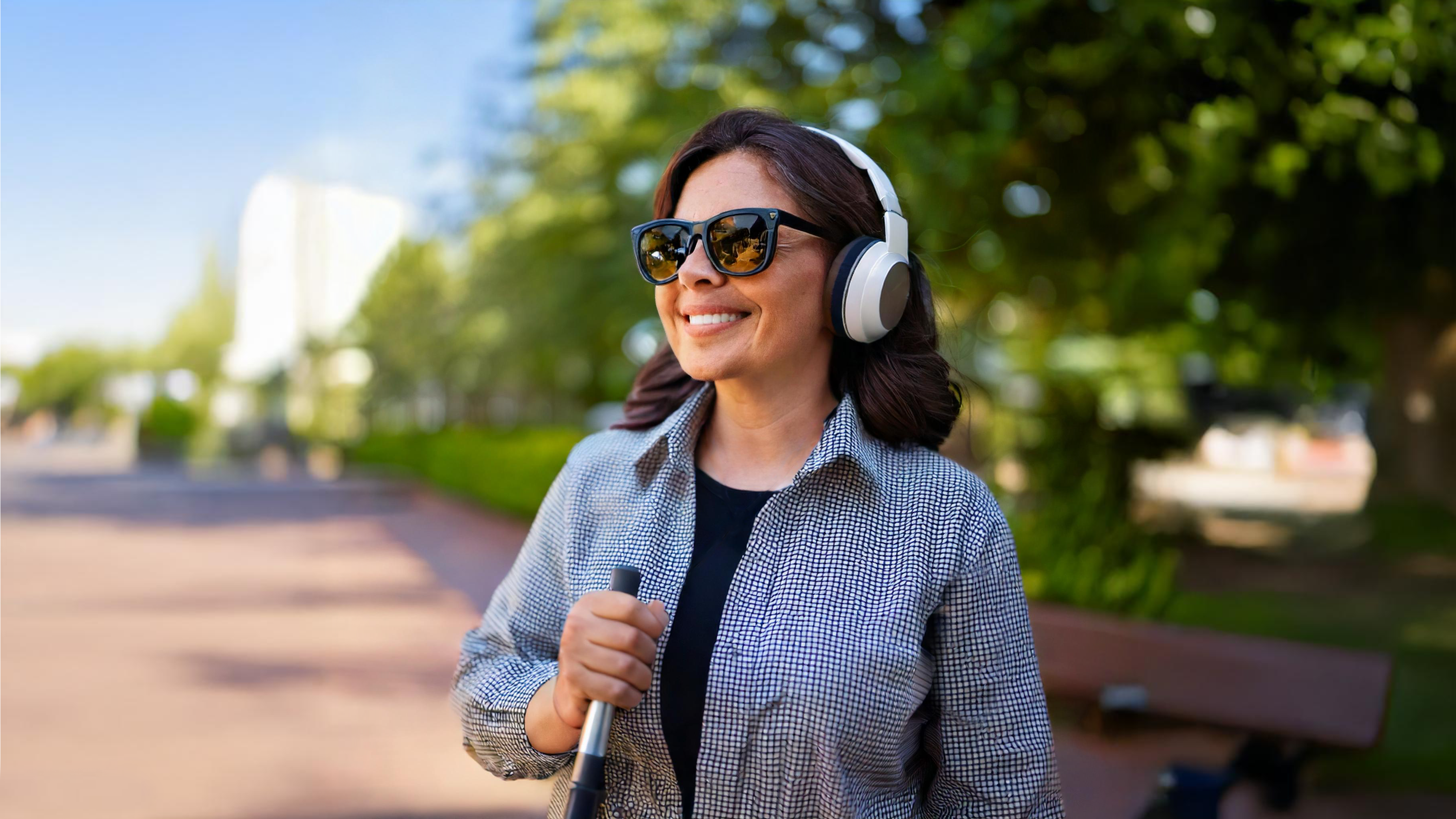 Mujer con bastón en parque con audífonos